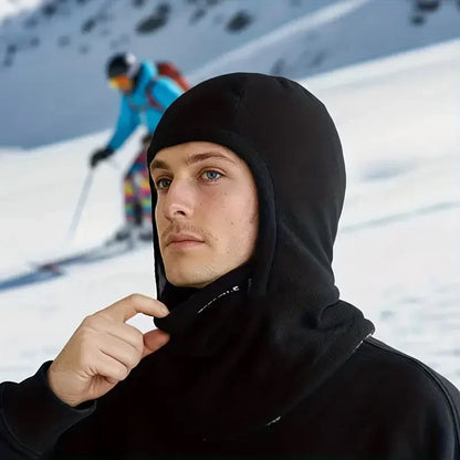 Man wearing the black balaclava with the hood up on a ski slope