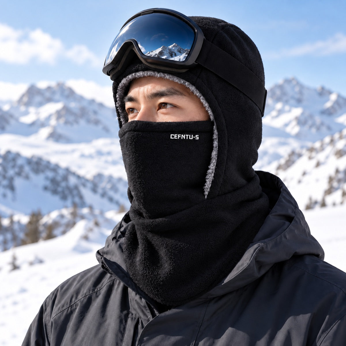 Skier wearing the black fleece balaclava with goggles on a snowy mountain